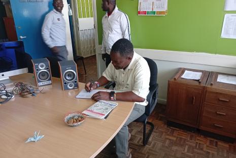 Mr Bob Nyaja signs the visitor's book
