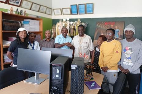 students from literature , Reuben Odanga & staff from the DOL receive the donations 